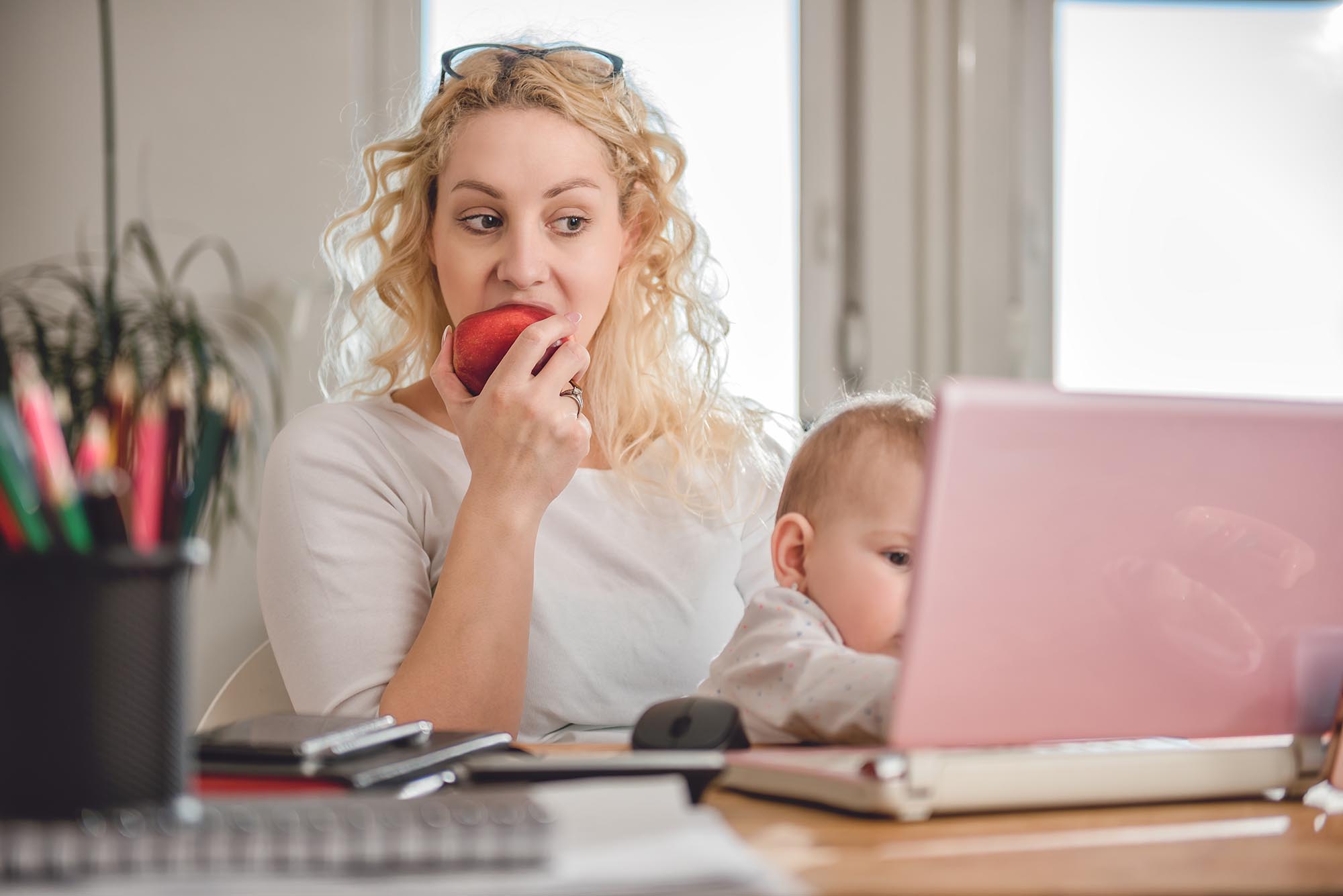 Mom working from home eating apple