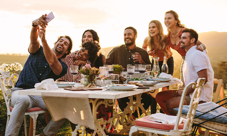 A group of people sitting outdoors around a picnic bench sharing Atkins meals