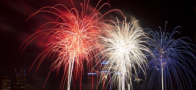 Red, white, and blue fireworks in the night sky.